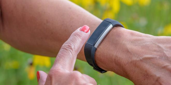 A woman using her fitness wristband.