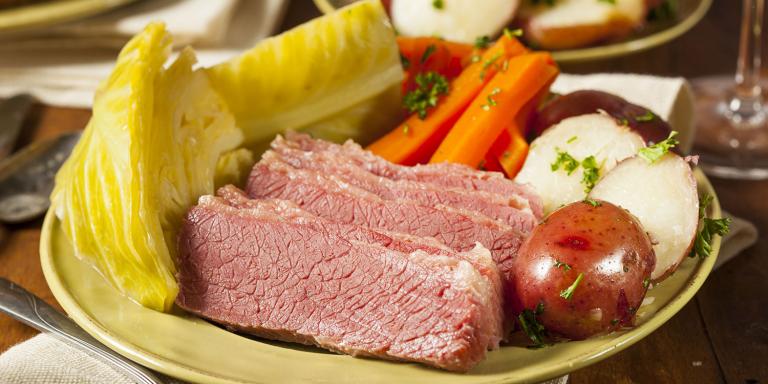 A plate of corned beef and cabbage with potatoes and carrots